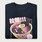 Folded navy blue sweatshirt with Japanese text and a kawaii ramen bowl graphic.