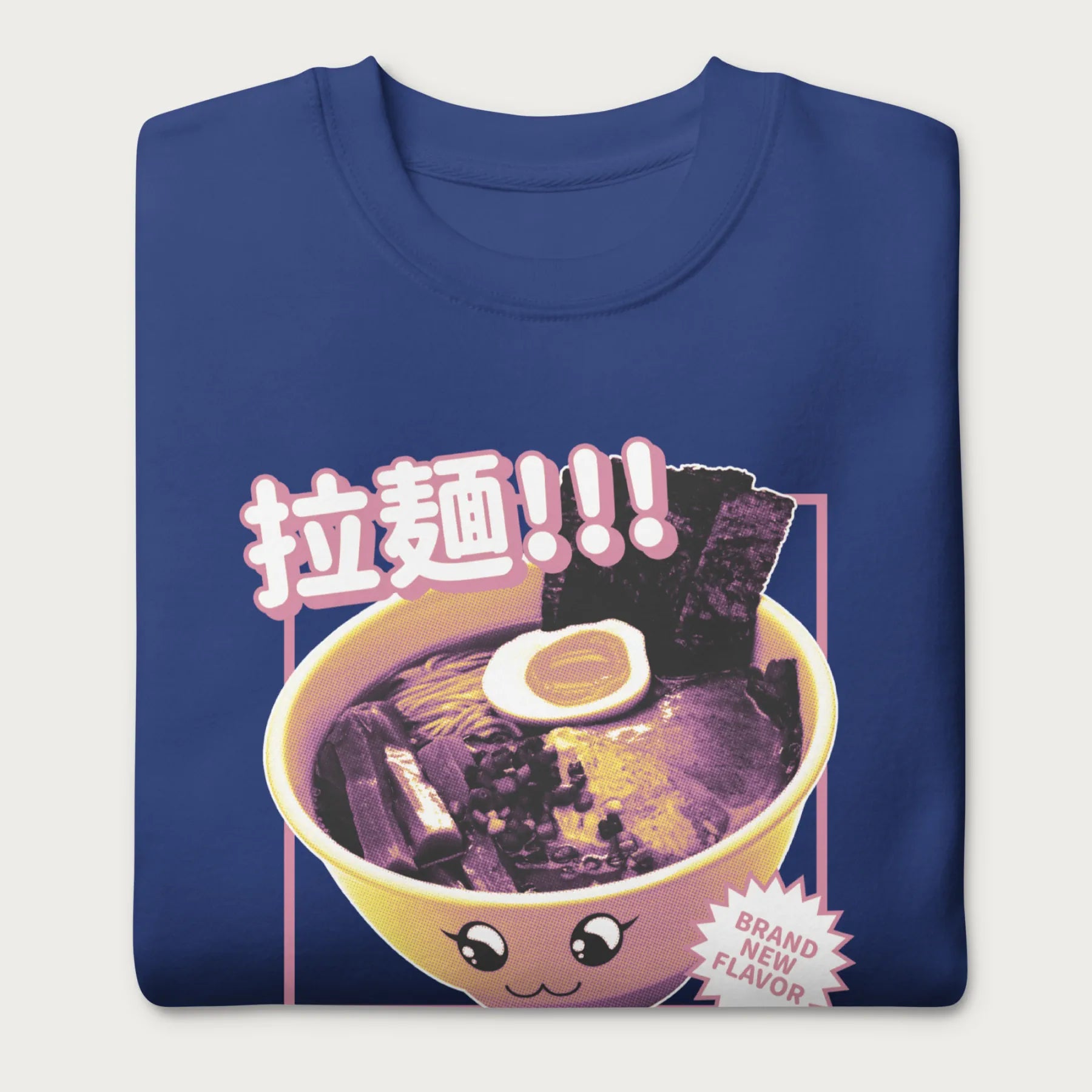 Folded royal blue sweatshirt with Japanese text and a kawaii ramen bowl graphic.