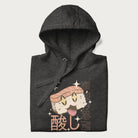 Folded dark grey hoodie with Japanese graphic of a cute sushi with sparkling eyes accompanied by Japanese text '寿司の時間' (Sushi Time).