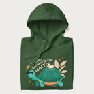 Folded forest green hoodie with graphic of a turtle and duck with sunglasses and the text 'Late but Worth the Wait'.