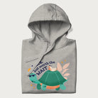 Folded light grey hoodie with graphic of a turtle and duck with sunglasses and the text 'Late but Worth the Wait'.