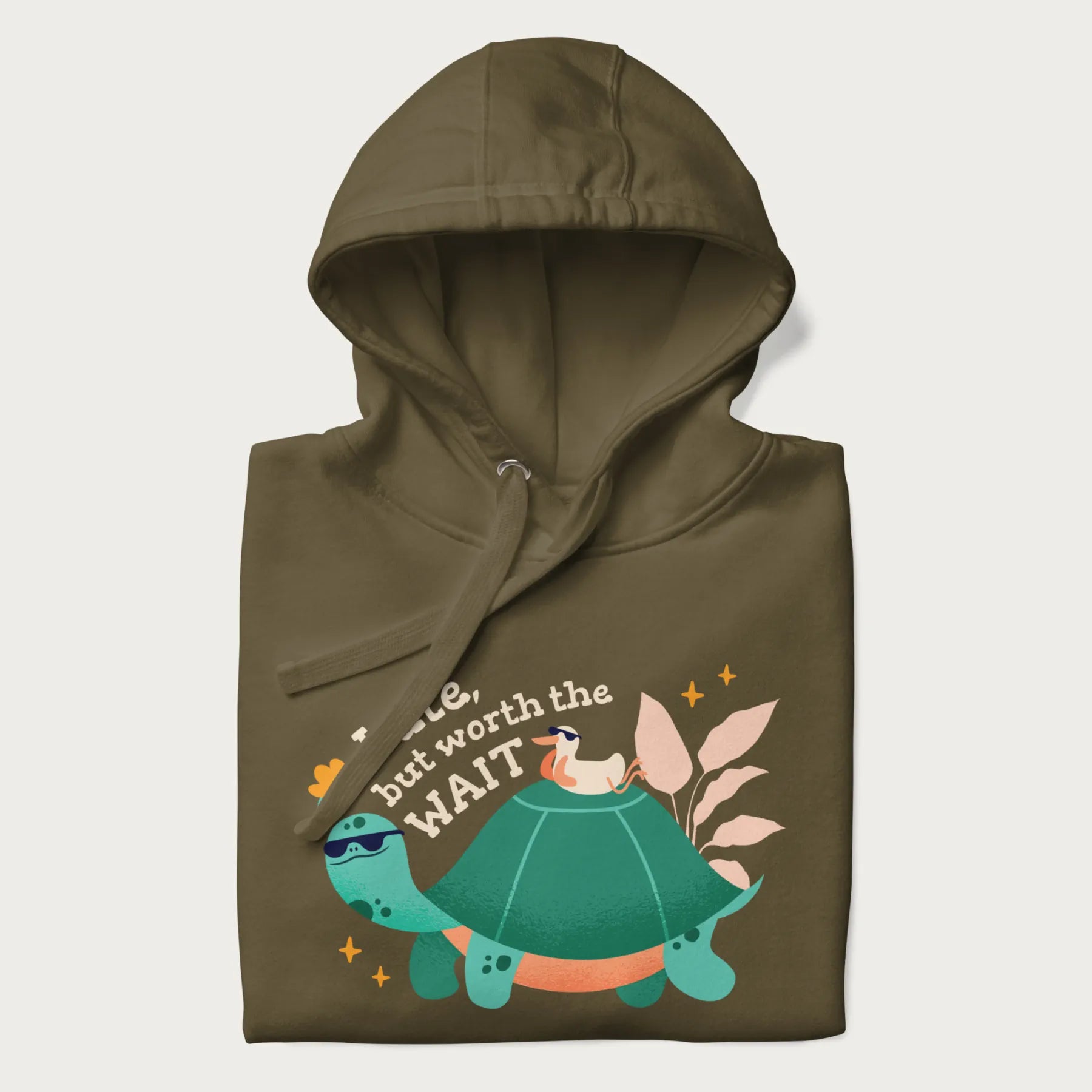 Folded military green hoodie with graphic of a turtle and duck with sunglasses and the text 'Late but Worth the Wait'.