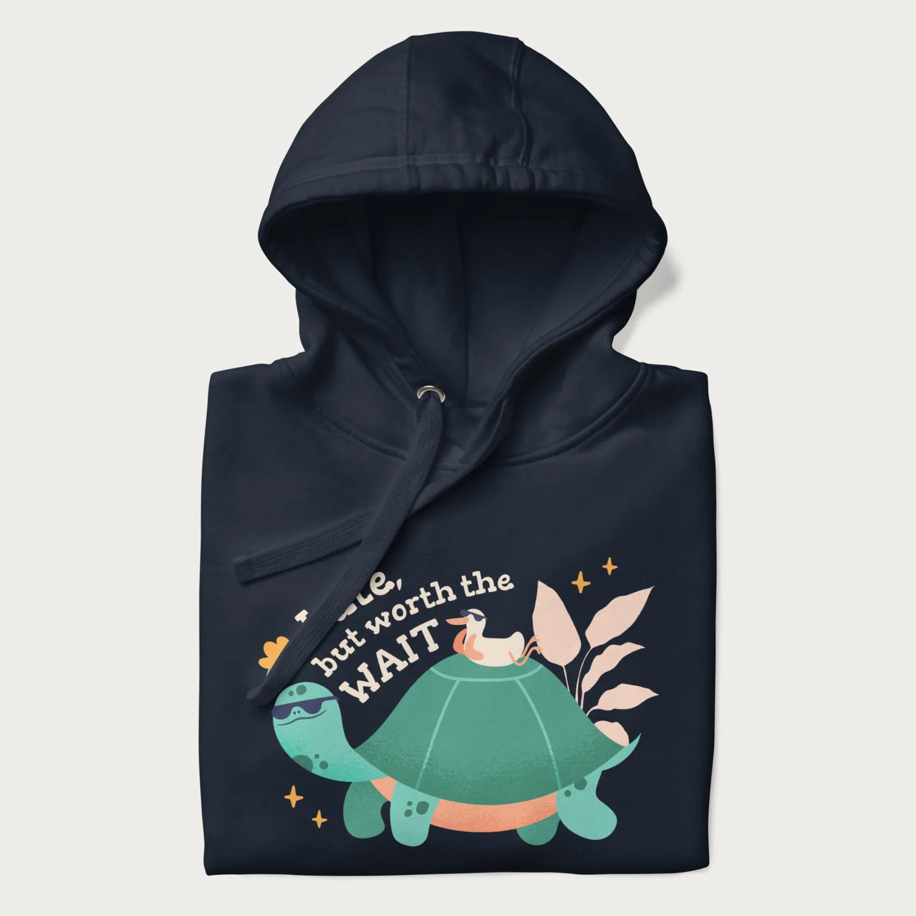 Folded navy blue hoodie with graphic of a turtle and duck with sunglasses and the text 'Late but Worth the Wait'.