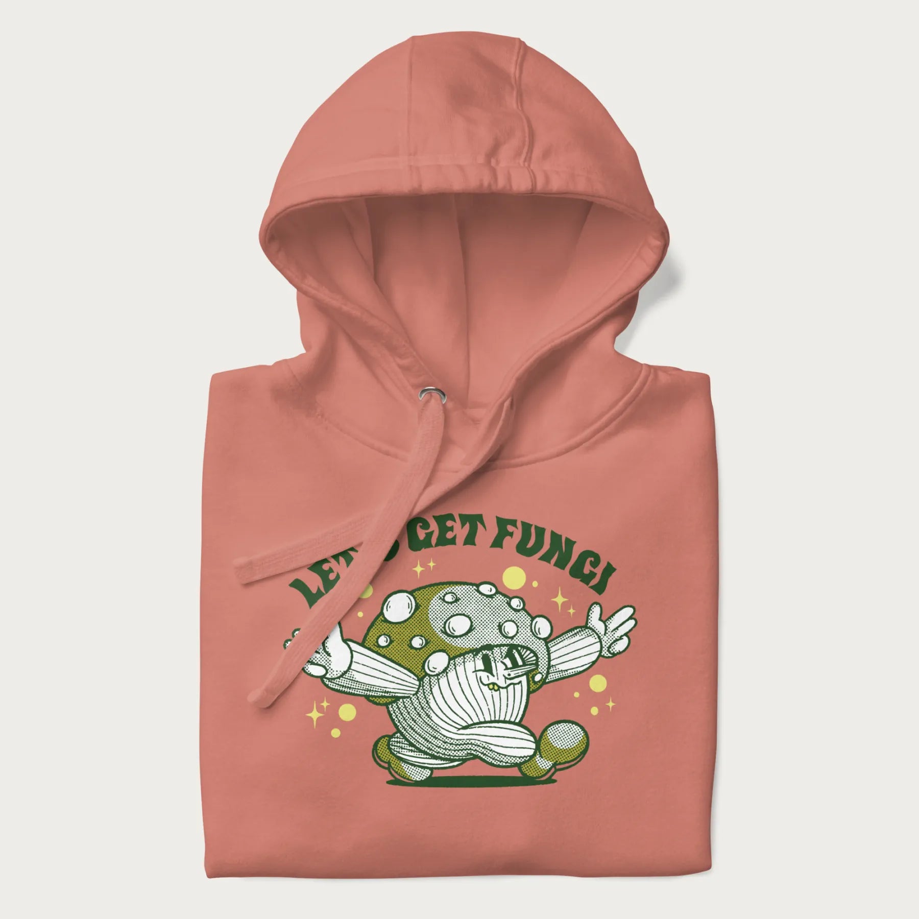 Folded light pink hoodie with a retro-inspired graphic of a mushroom mascot character and the text 'Let's Get Fungi'.