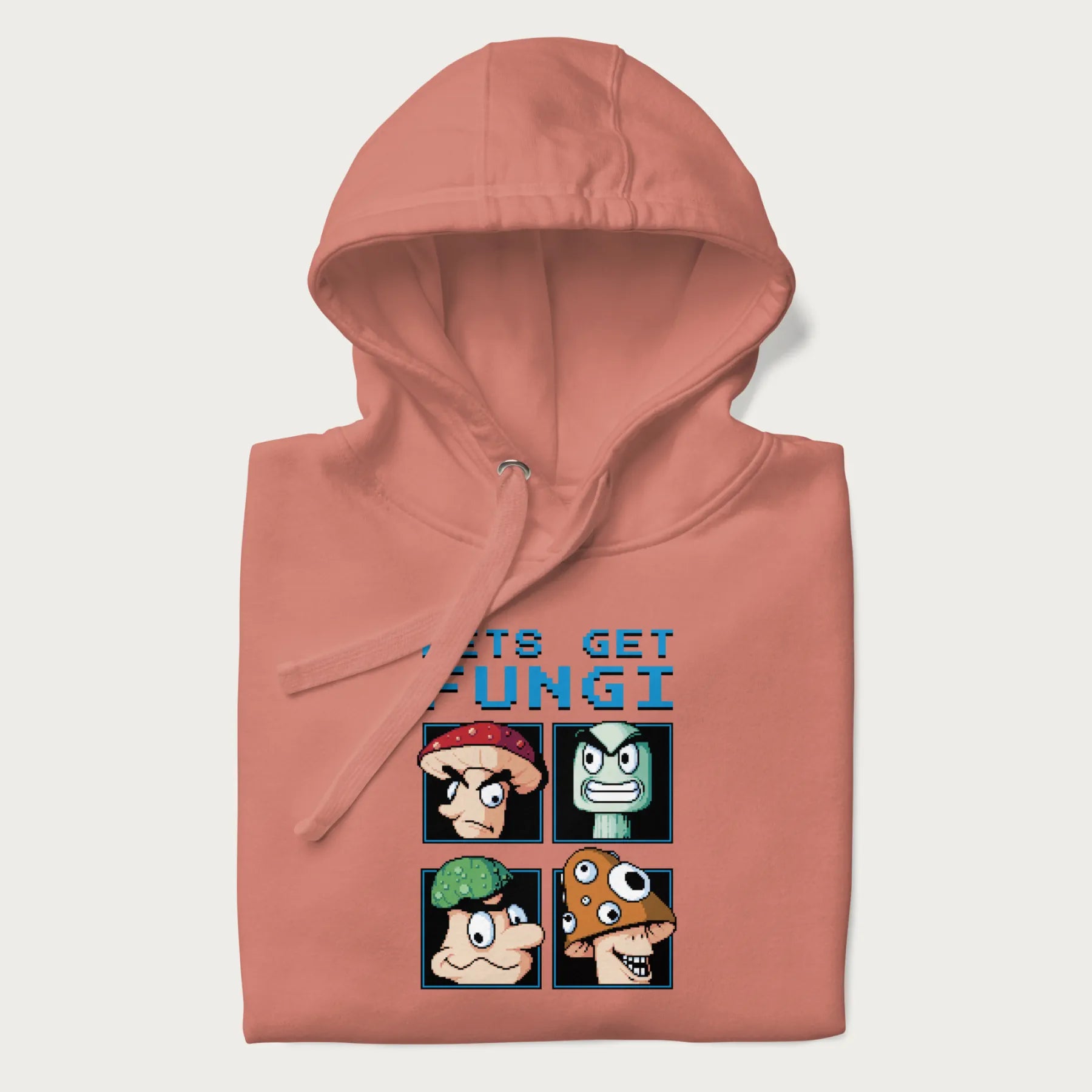 Folded light pink hoodie with a pixel art graphic of four mushroom characters and the text 'Let's Get Fungi'.