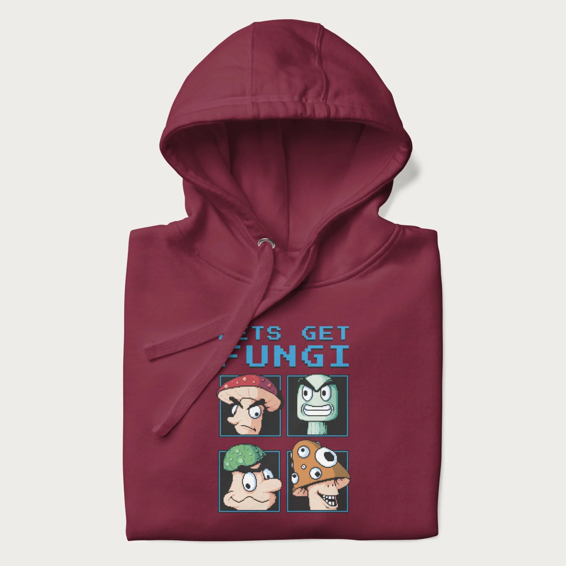 Folded maroon hoodie with a pixel art graphic of four mushroom characters and the text 'Let's Get Fungi'.