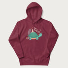 Maroon hoodie with a graphic of a turtle with a duck on its back and the text 'Let's Win the Race'.