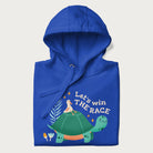 Folded royal blue hoodie with a graphic of a turtle with a duck on its back and the text 'Let's Win the Race'.