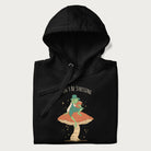 Folded black hoodie with graphic of a dapper frog reading a book on a mushroom with the text 'Don't Be Stressing, Life's a Blessing' above and below.