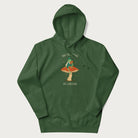 Forest green hoodie with graphic of a dapper frog reading a book on a mushroom with the text 'Don't Be Stressing, Life's a Blessing' above and below.