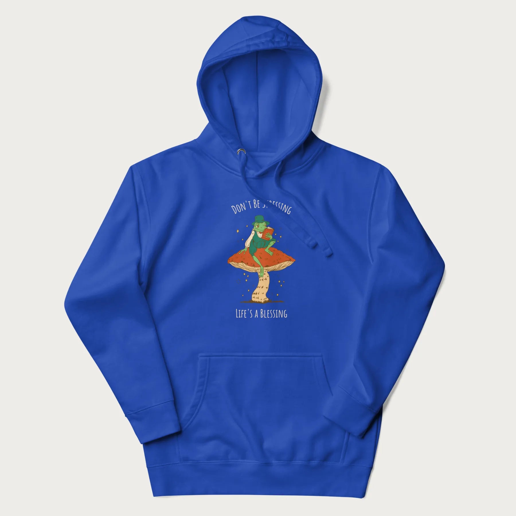 Royal blue hoodie with graphic of a dapper frog reading a book on a mushroom with the text 'Don't Be Stressing, Life's a Blessing' above and below.