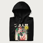 Folded black hoodie with Japanese graphic of a mech warrior in vibrant green and red, with Japanese characters symbolizing battle and courage.