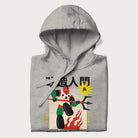 Folded light grey hoodie with Japanese graphic of a mech warrior in vibrant green and red, with Japanese characters symbolizing battle and courage.