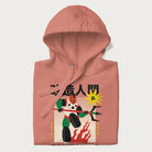 Folded light pink hoodie with Japanese graphic of a mech warrior in vibrant green and red, with Japanese characters symbolizing battle and courage.