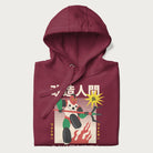 Folded maroon hoodie with Japanese graphic of a mech warrior in vibrant green and red, with Japanese characters symbolizing battle and courage.