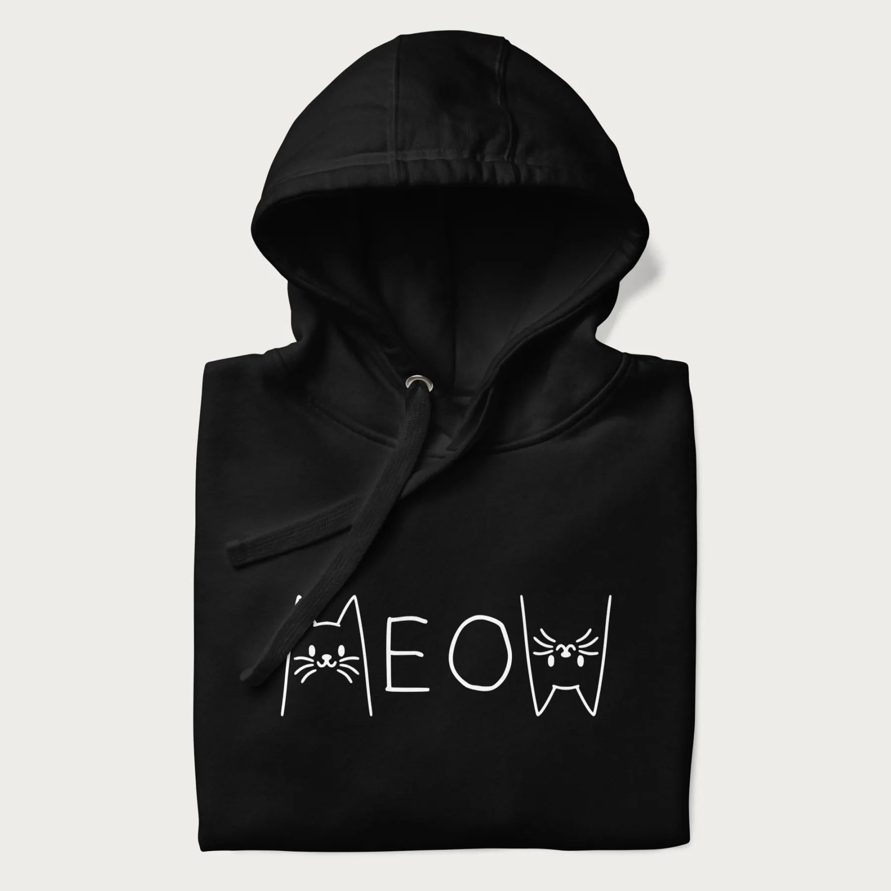 Folded black meow hoodie with a simple 'MEOW' text and cute cat face graphics on the front.