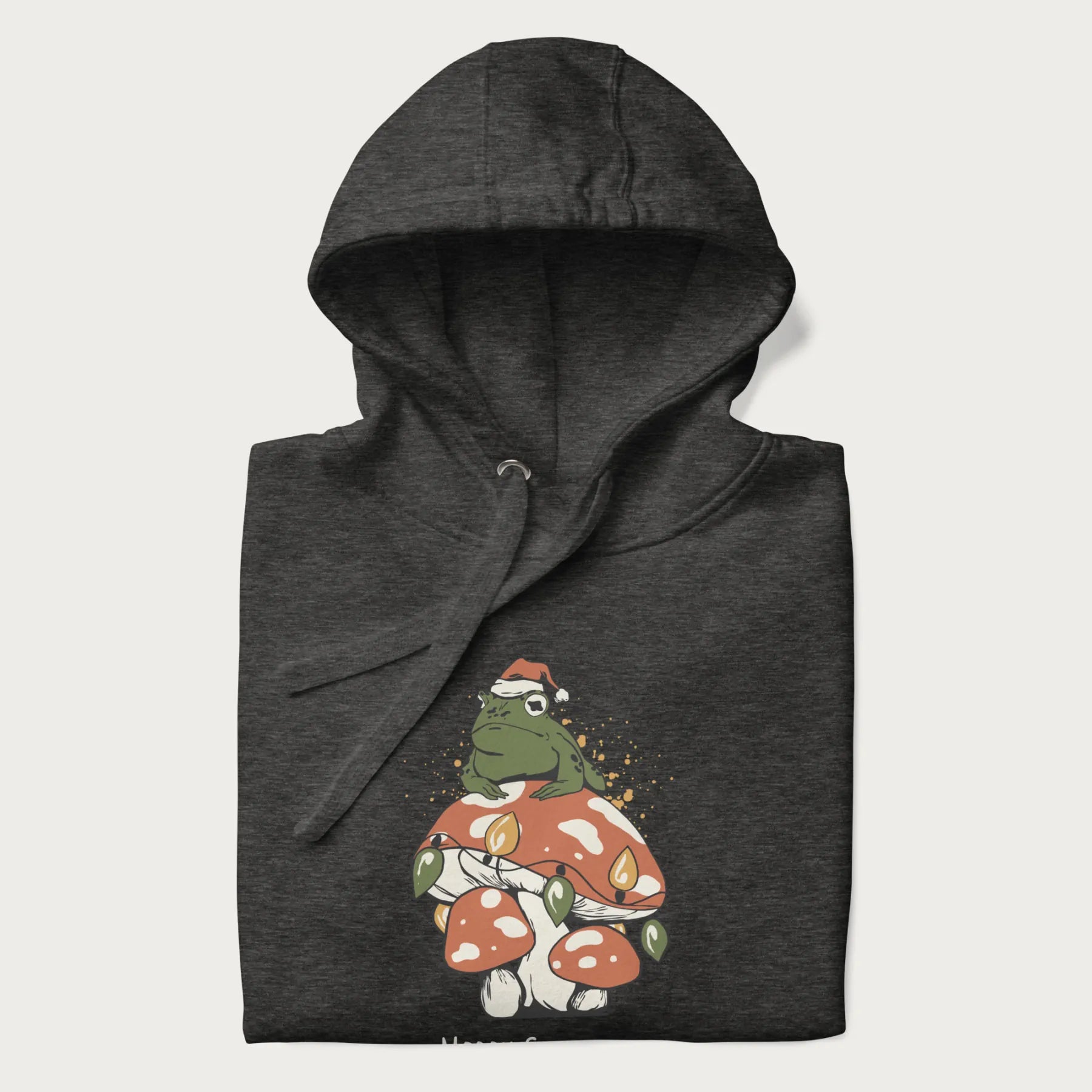 Folded dark grey hoodie with graphic of a frog in a Santa hat on a mushroom with Christmas lights and the text 'Merry Christmas' below.