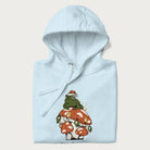 Folded light blue hoodie with graphic of a frog in a Santa hat on a mushroom with Christmas lights and the text 'Merry Christmas' below.