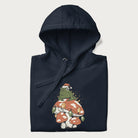 Folded navy blue hoodie with graphic of a frog in a Santa hat on a mushroom with Christmas lights and the text 'Merry Christmas' below.