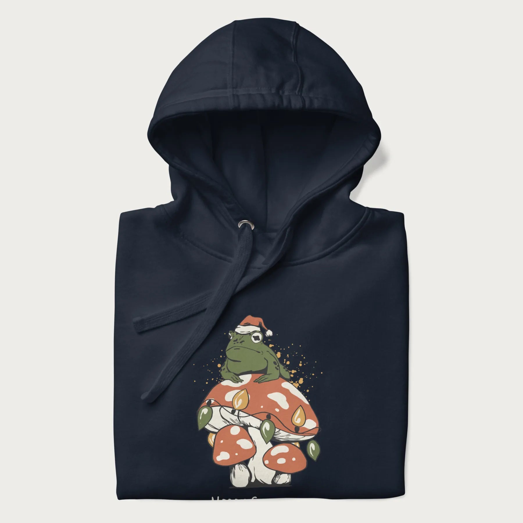 Folded navy blue hoodie with graphic of a frog in a Santa hat on a mushroom with Christmas lights and the text 'Merry Christmas' below.