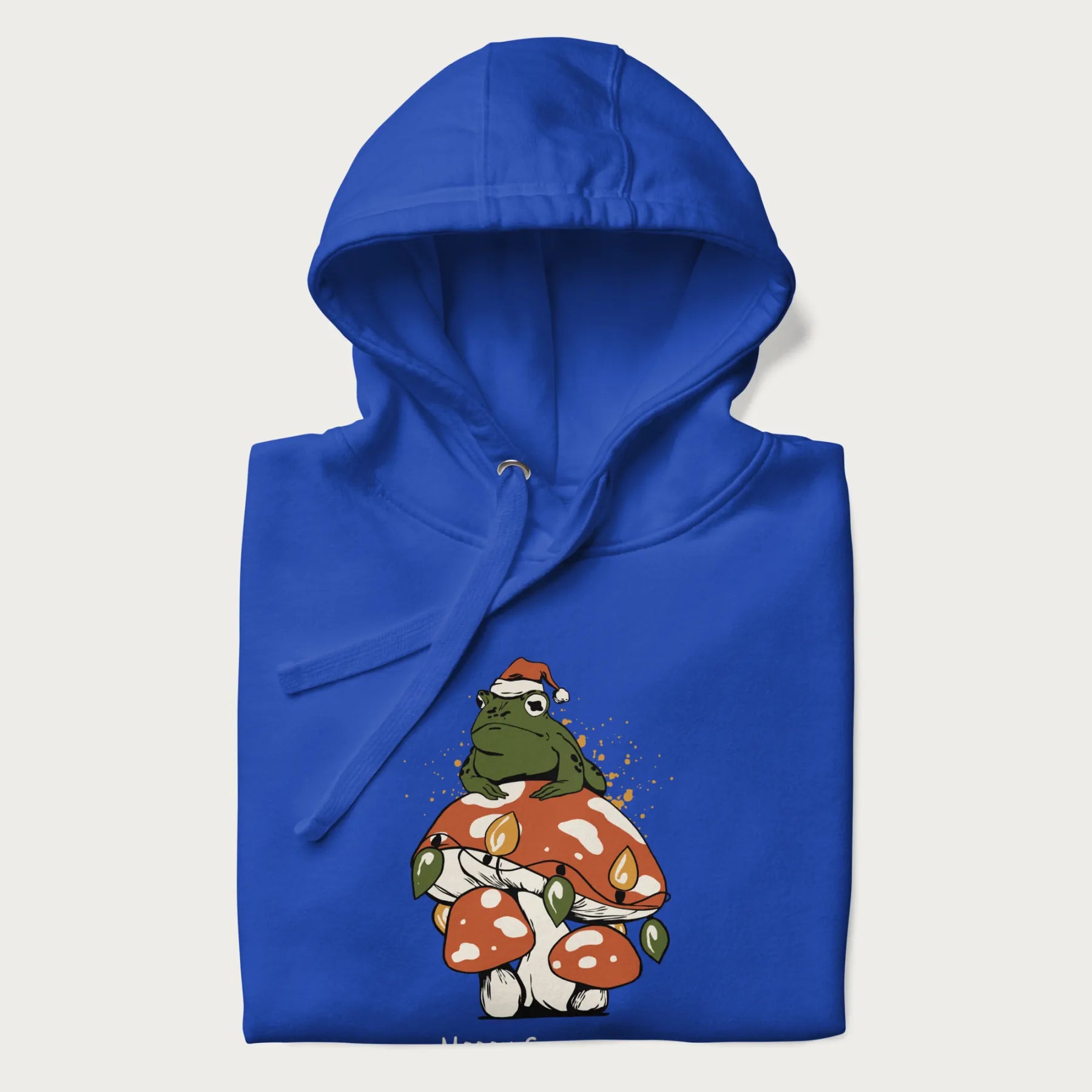 Folded royal blue hoodie with graphic of a frog in a Santa hat on a mushroom with Christmas lights and the text 'Merry Christmas' below.