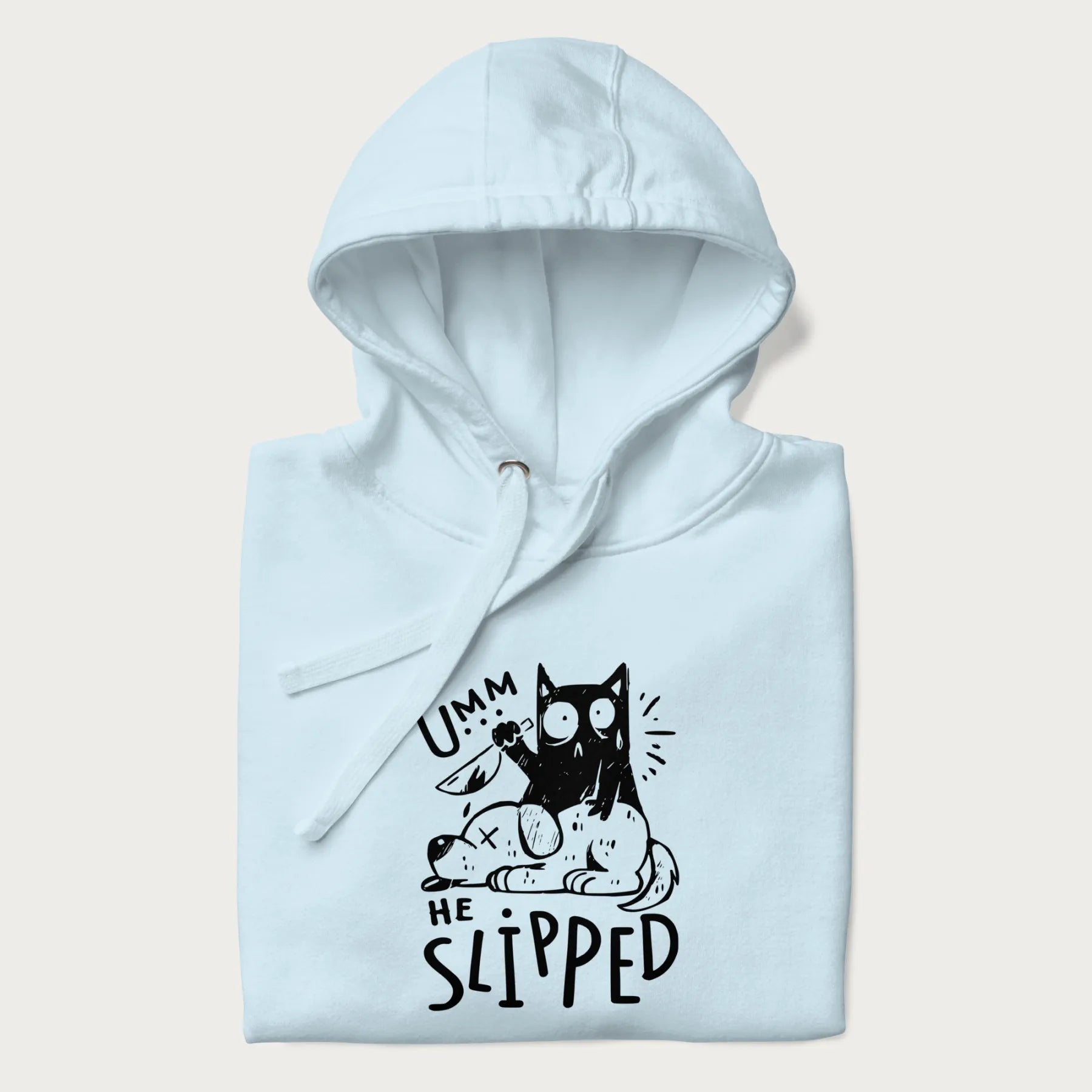 Folded light blue hoodie with a graphic of a black cat holding a knife over a dog with a funny phrase 'Umm, He Slipped'.