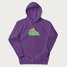 Purple hoodie with a cottagecore design of a green frog wearing a mushroom cap and a snail on top.