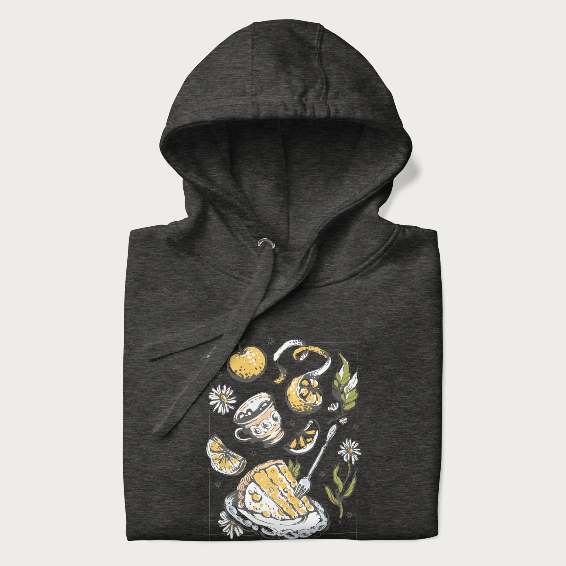 Folded dark grey hoodie featuring a Cottagecore-themed graphic with oranges, a floral porcelain cup, orange pie, and daisies.