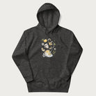 Dark grey hoodie featuring a Cottagecore-themed graphic with oranges, a floral porcelain cup, orange pie, and daisies.