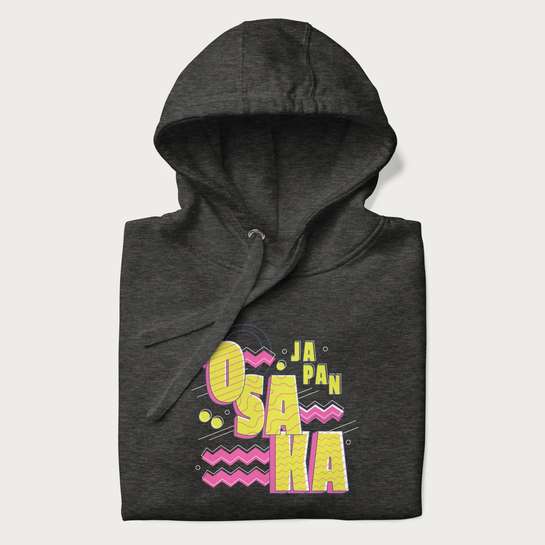 Folded dark grey hoodie featuring a colorful 'OSAKA JAPAN' pop art design in bold pink and yellow, with abstract geometric shapes.