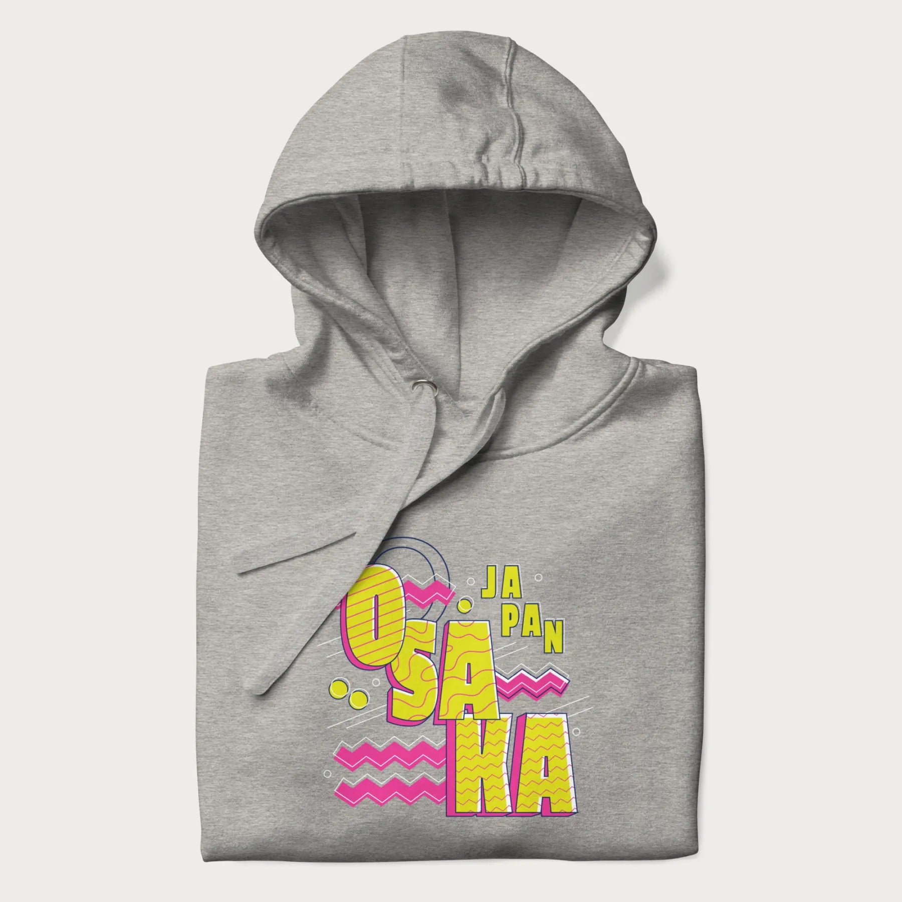 Folded light grey hoodie featuring a colorful 'OSAKA JAPAN' pop art design in bold pink and yellow, with abstract geometric shapes.