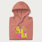 Folded light pink hoodie featuring a colorful 'OSAKA JAPAN' pop art design in bold pink and yellow, with abstract geometric shapes.