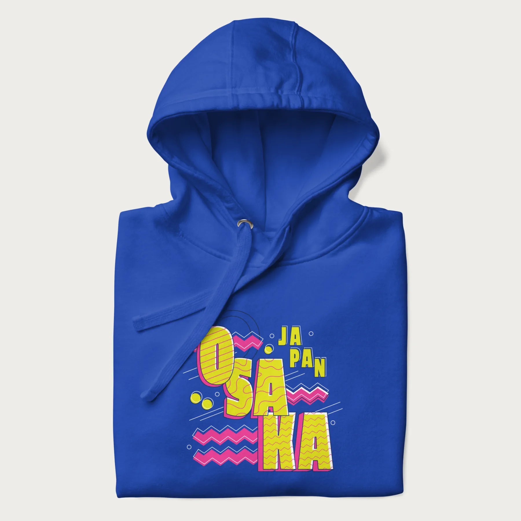 Folded royal blue hoodie featuring a colorful 'OSAKA JAPAN' pop art design in bold pink and yellow, with abstract geometric shapes.