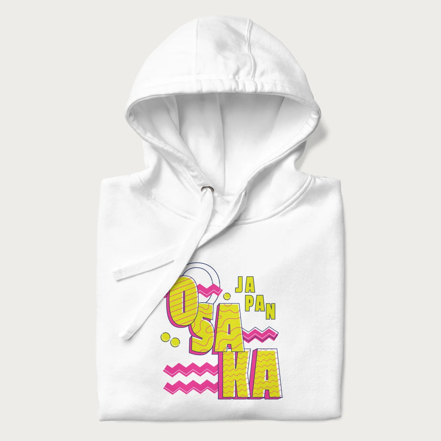 Folded white hoodie featuring a colorful 'OSAKA JAPAN' pop art design in bold pink and yellow, with abstract geometric shapes.