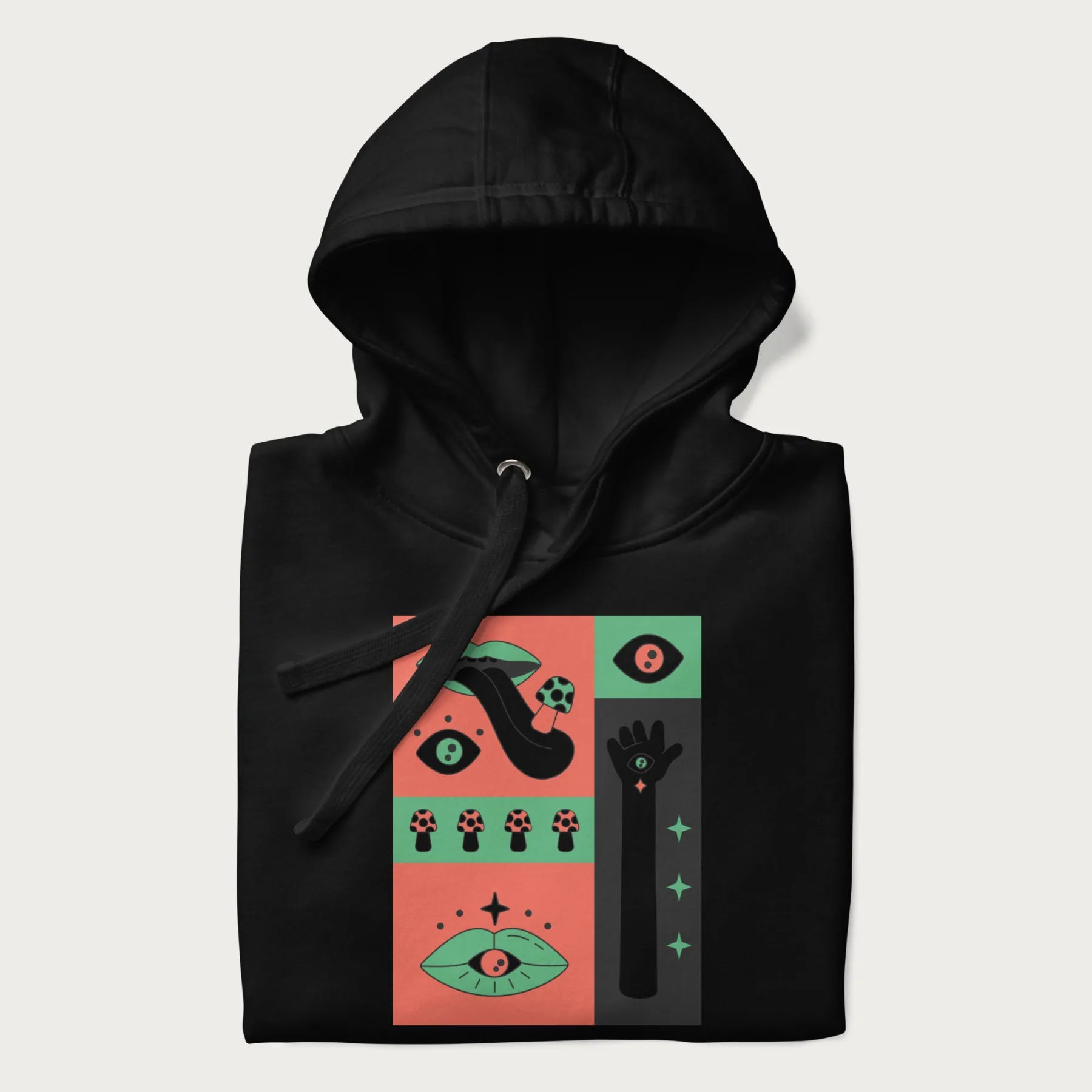 Folded black hoodie with mushroom psychedelic designs of surreal elements like lips, eyes, and mushrooms.