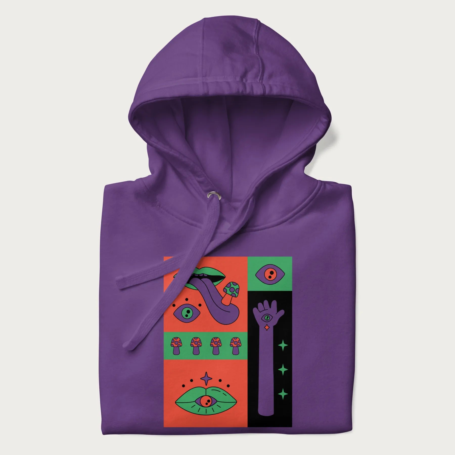 Folded purple hoodie with mushroom psychedelic designs of surreal elements like lips, eyes, and mushrooms.
