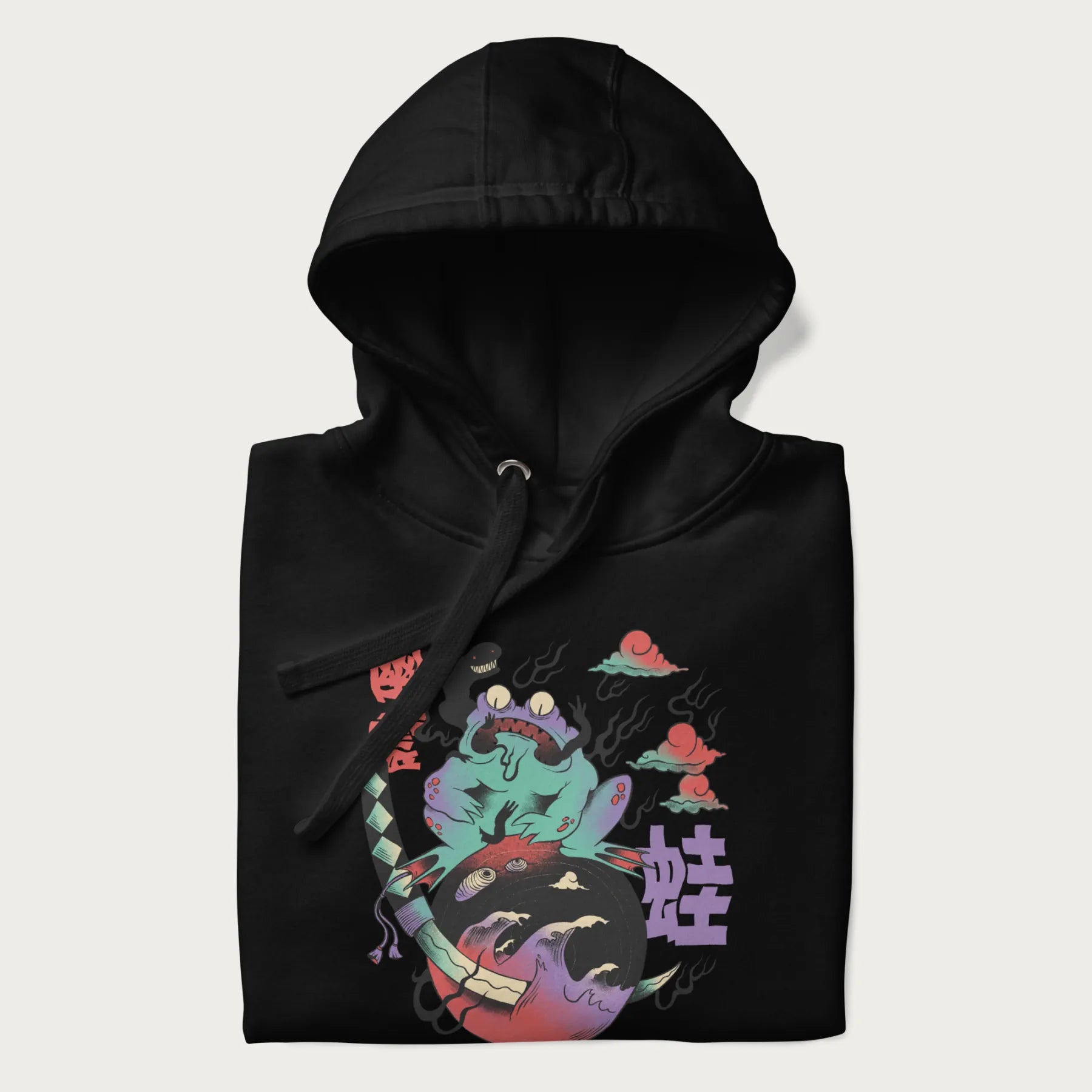 Folded black hoodie with Japanese psychedelic graphic of a frog with text '蛙' (Frog) and '幽靈' (Ghost) in Japanese characters.