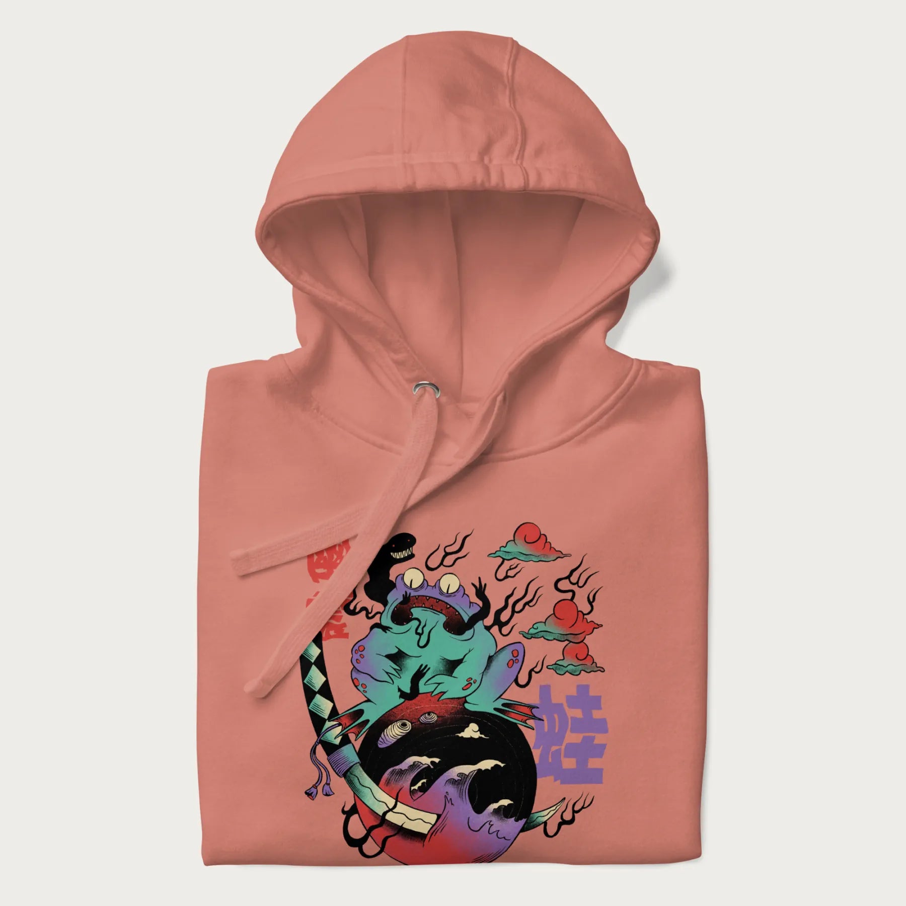 Folded light pink hoodie with Japanese psychedelic graphic of a frog with text '蛙' (Frog) and '幽靈' (Ghost) in Japanese characters.