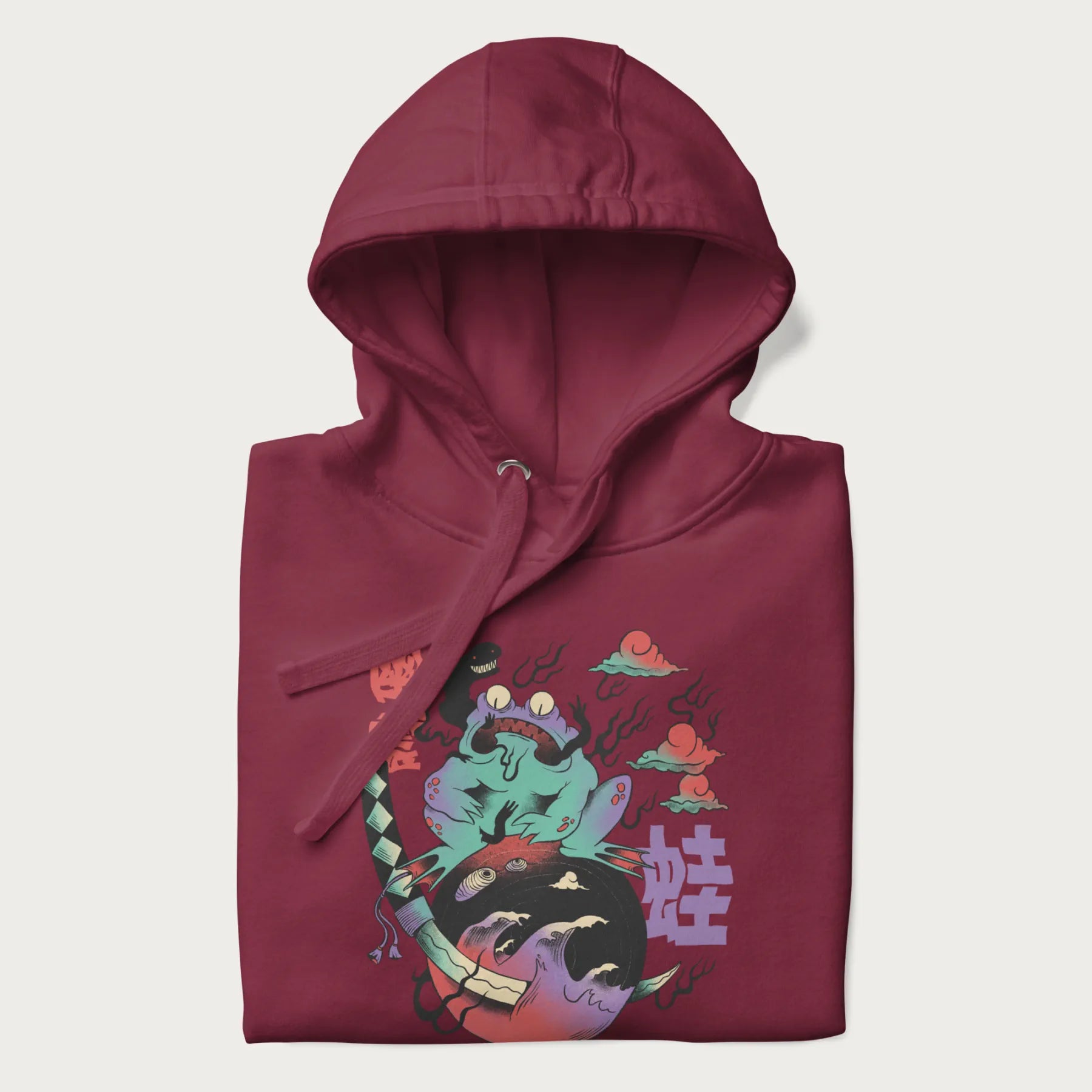 Folded maroon hoodie with Japanese psychedelic graphic of a frog with text '蛙' (Frog) and '幽靈' (Ghost) in Japanese characters.