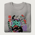 Folded light grey sweatshirt with a psychedelic Japanese frog graphic in vibrant colors with Japanese text.