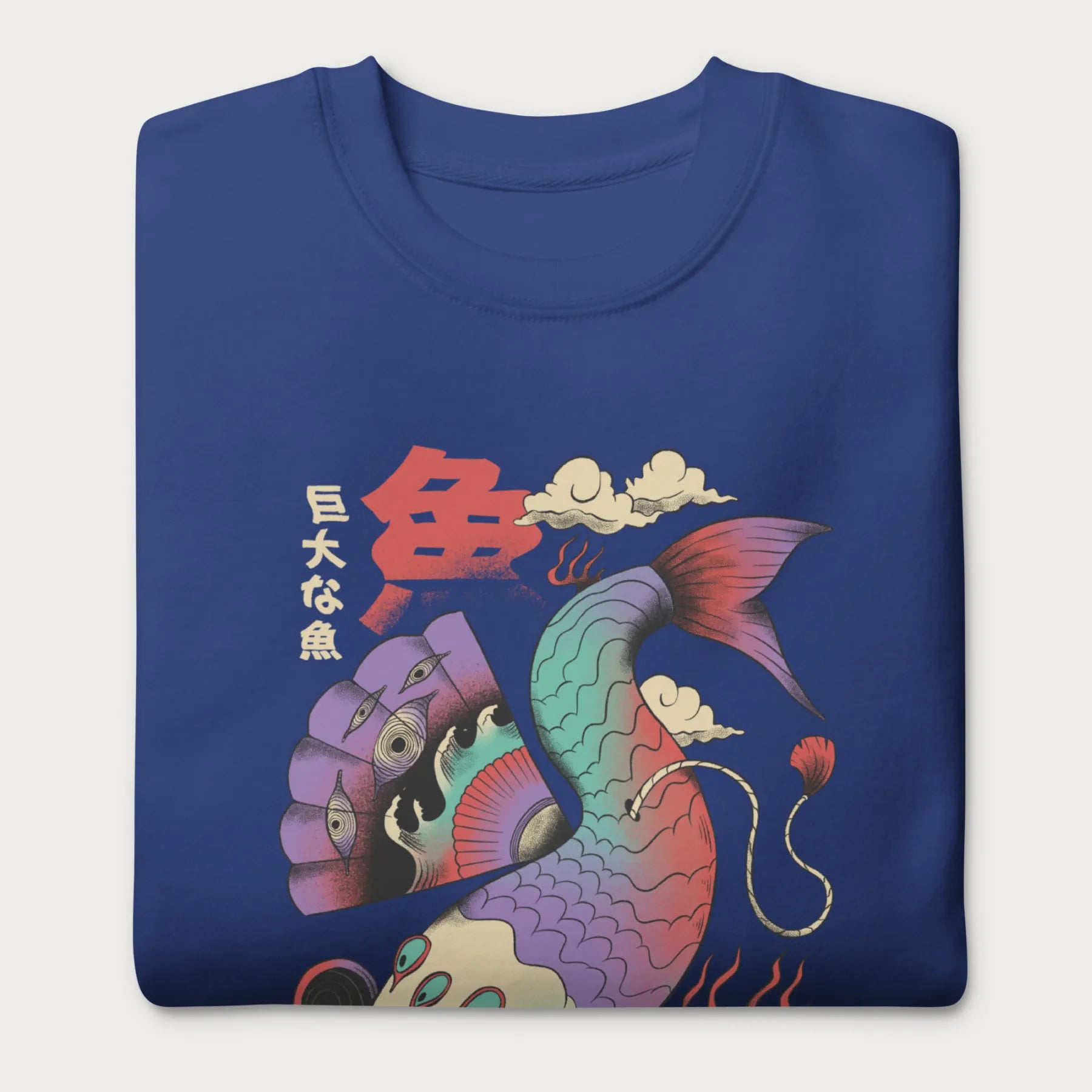 Folded royal blue sweatshirt with a vibrant psychedelic Japanese koi fish graphic featuring intricate details and Japanese text.