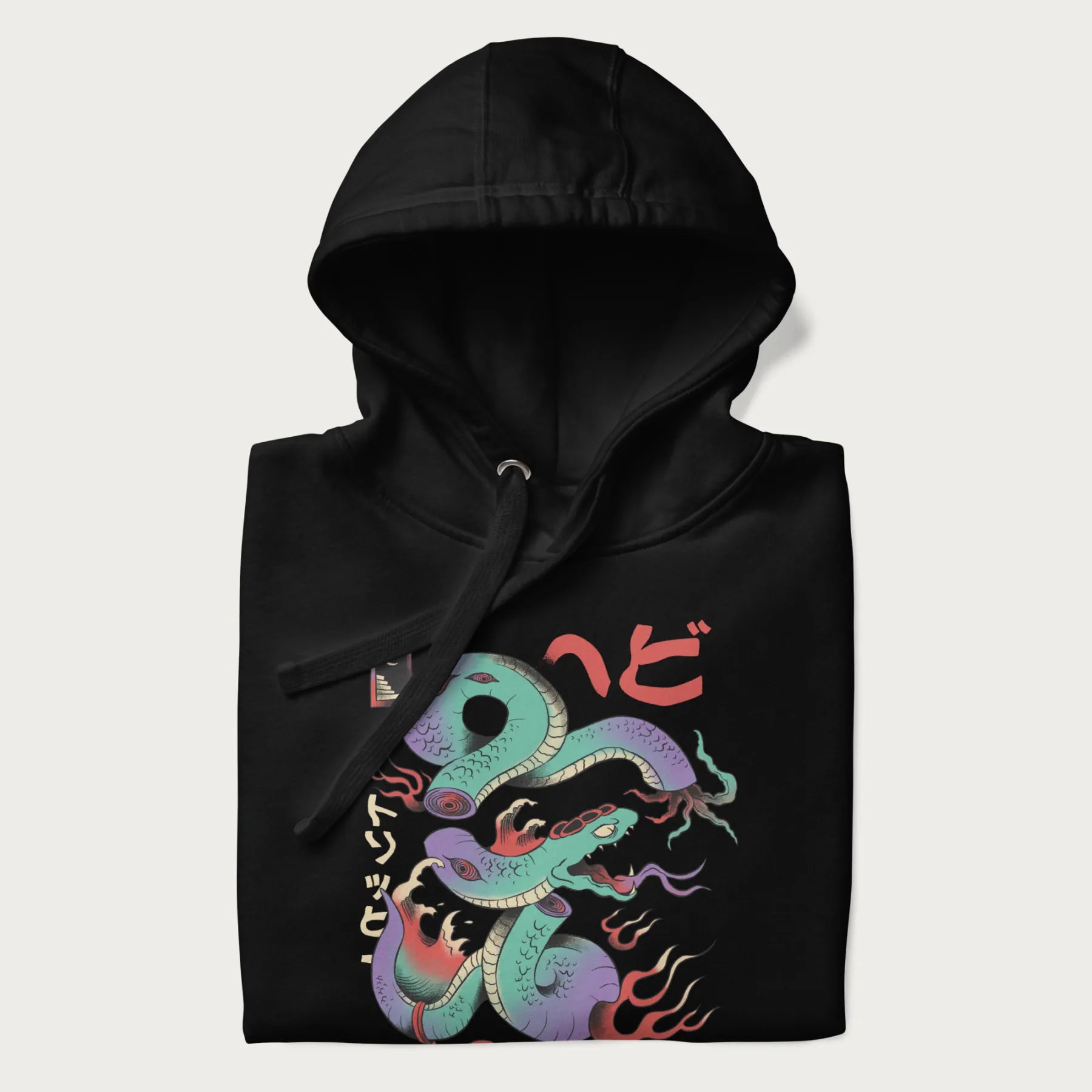 Folded black hoodie with Japanese psychedelic snake graphic, with Japanese text 'ヘビ' (Snake) and 'トリッピー' (Trippy) in vibrant colors.