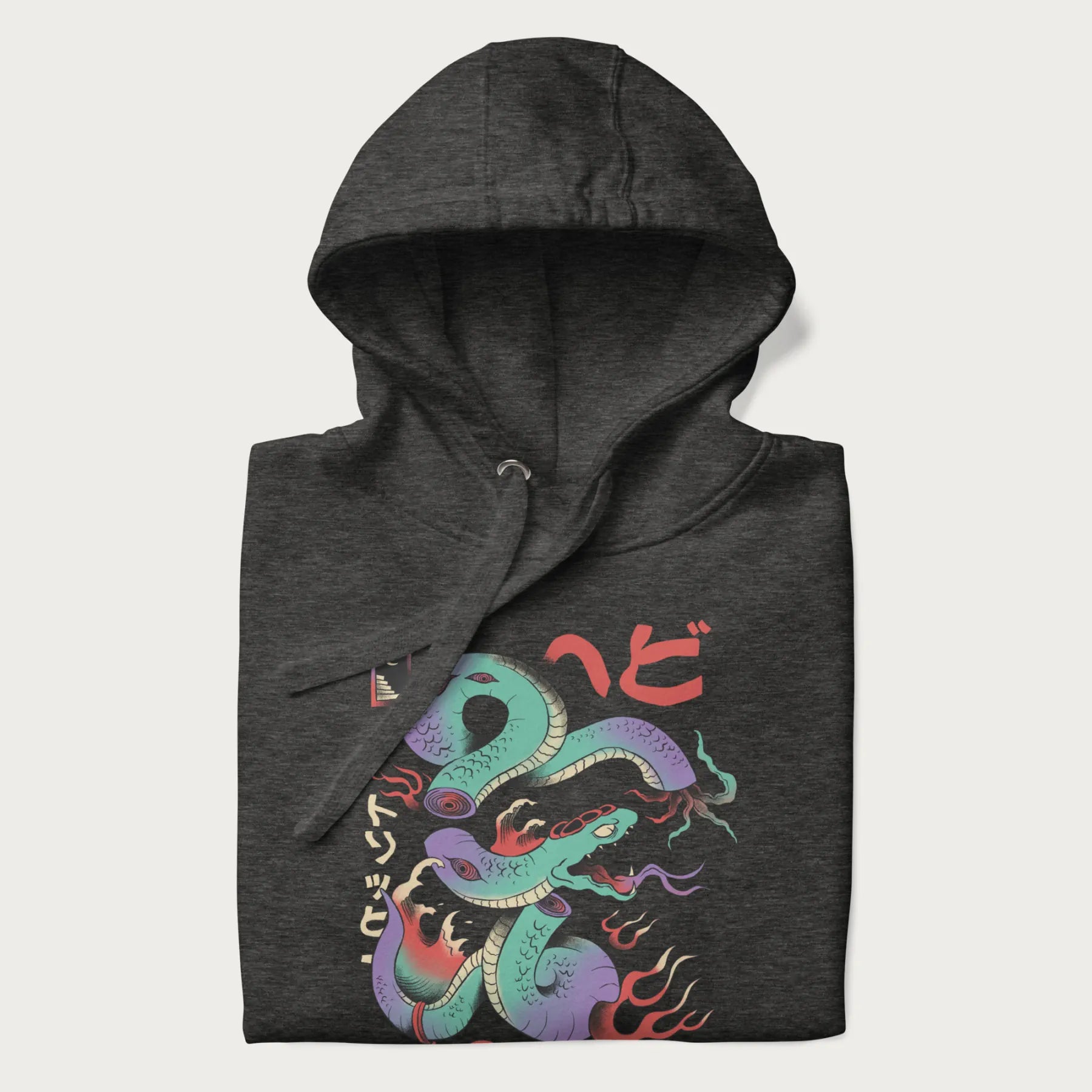 Folded dark grey hoodie with Japanese psychedelic snake graphic, with Japanese text 'ヘビ' (Snake) and 'トリッピー' (Trippy) in vibrant colors.