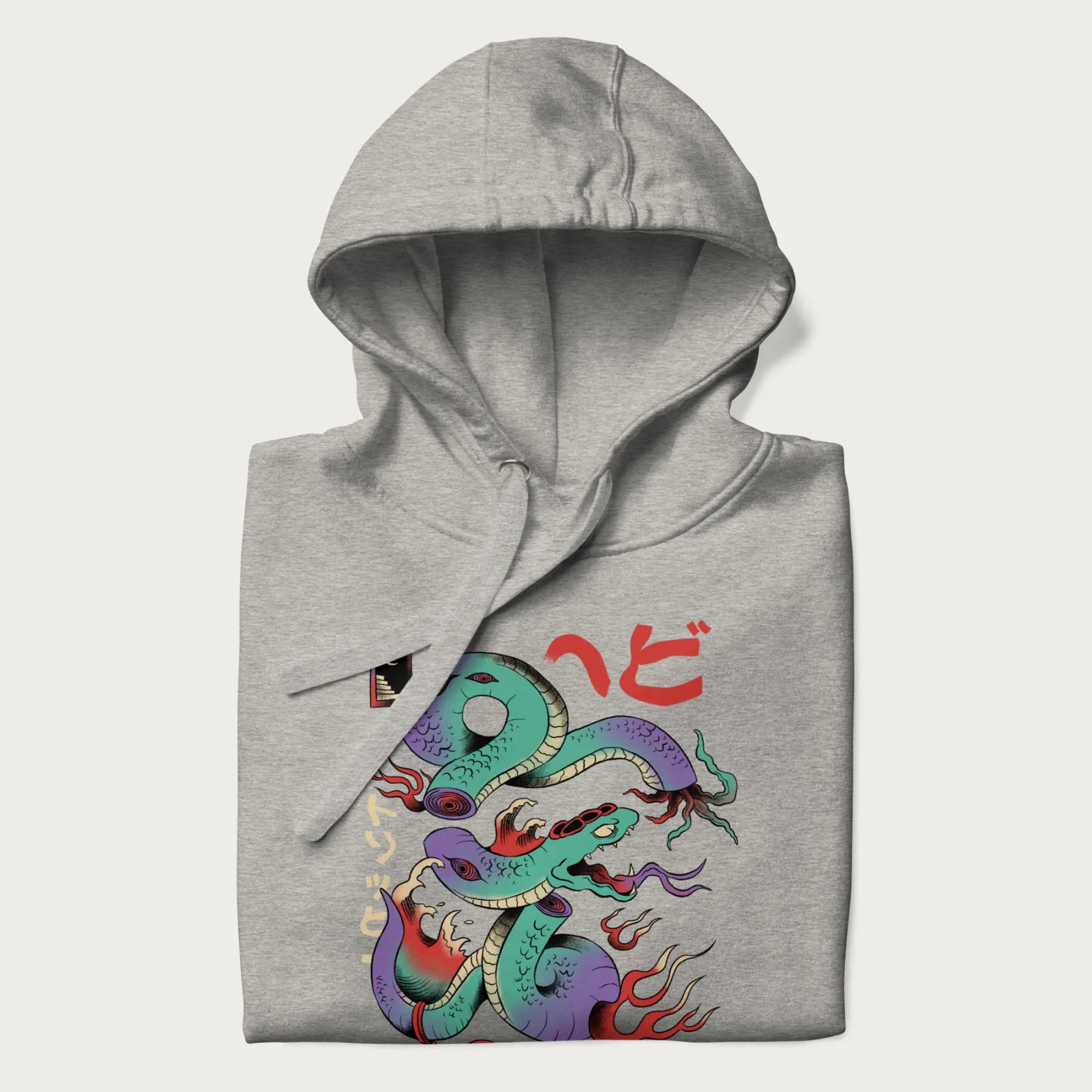 Folded light grey hoodie with Japanese psychedelic snake graphic, with Japanese text 'ヘビ' (Snake) and 'トリッピー' (Trippy) in vibrant colors.