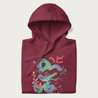 Folded maroon hoodie with Japanese psychedelic snake graphic, with Japanese text 'ヘビ' (Snake) and 'トリッピー' (Trippy) in vibrant colors.