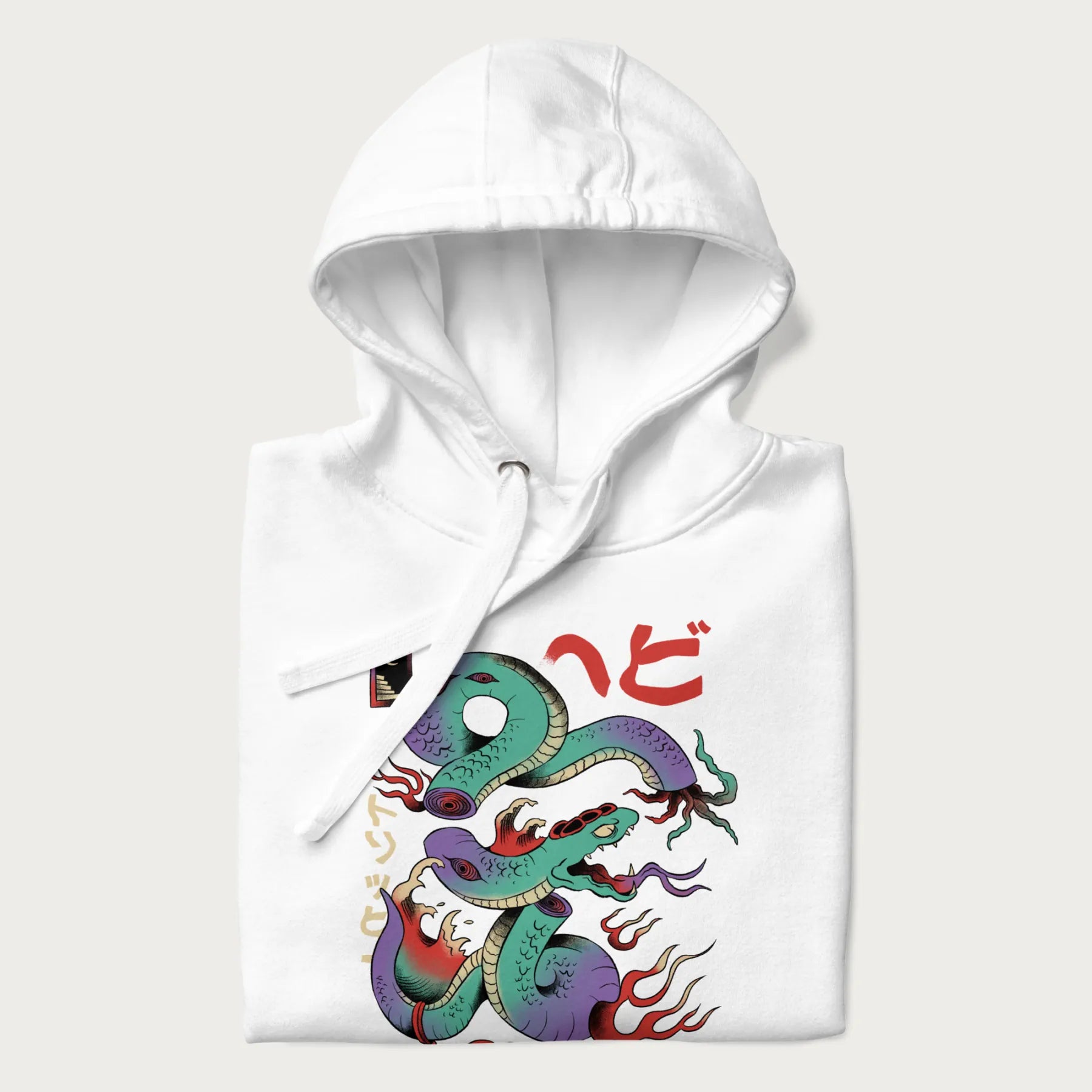 Folded white hoodie with Japanese psychedelic snake graphic, with Japanese text 'ヘビ' (Snake) and 'トリッピー' (Trippy) in vibrant colors.