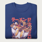 Folded royal blue sweatshirt with a vibrant graphic of a bowl of ramen noodles, depicted in a dynamic, cartoonish style with bold Japanese text.