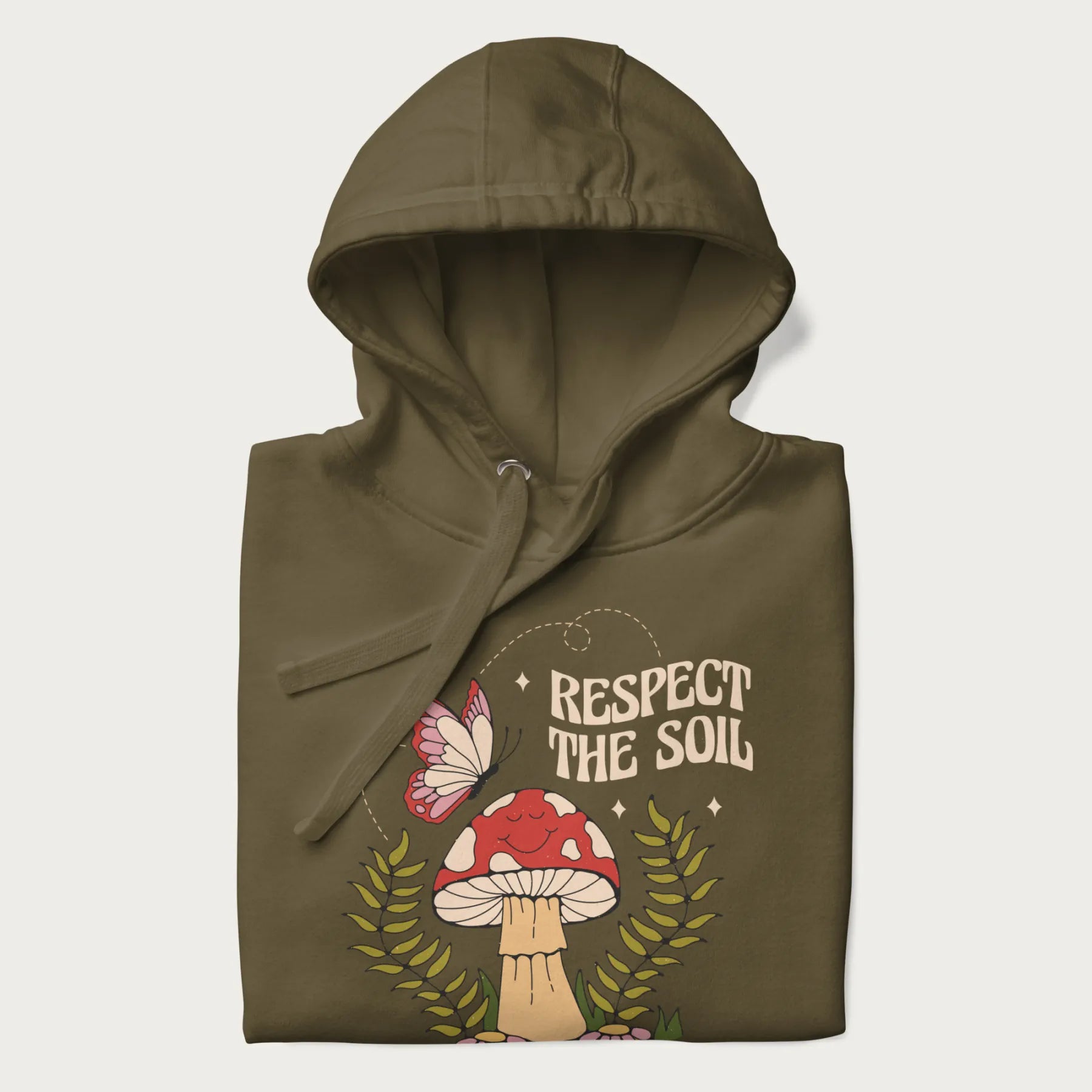 Folded military green hoodie with mushroom and butterfly design, with the text 'Respect the Soil' above it. 
