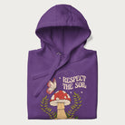 Folded purple hoodie with mushroom and butterfly design, with the text 'Respect the Soil' above it. 