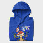 Folded royal blue hoodie with mushroom and butterfly design, with the text 'Respect the Soil' above it. 
